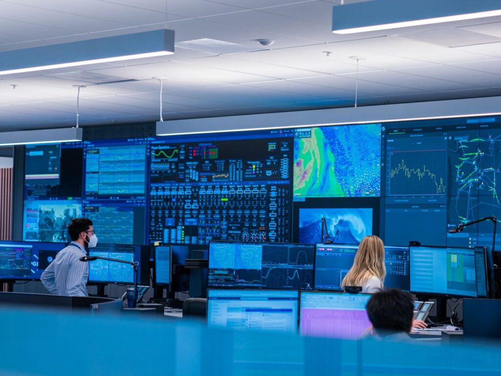 Pictured: A video wall display. composed of multiple displays, tiled together, with many sources of information being viewed by a control room team.